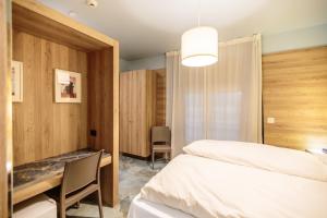 a bedroom with two beds and a desk and a table at Ferrucci Rooms in Marina di Cecina +23 photos