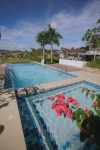 a swimming pool with flowers in the water at Villa Serena in Dauis