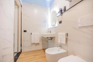 a white bathroom with a sink and a toilet at Ferrucci Rooms in Marina di Cecina