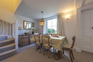a dining room with a table and chairs and a window at Hatchet Pond Cottage in Beaulieu