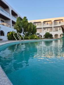 a swimming pool in front of a building at Three Oceans Resort in Kanyakumari