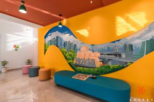 a room with a yellow wall with a mural of a city at Zostel Noida in Noida +28 photos