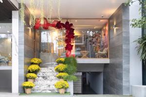 a lobby with a staircase with flowers and a chandelier at SHI HOUSE by Haviland in Danang