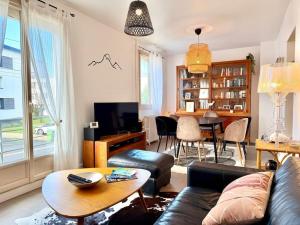 a living room with a couch and a table at Le Chapelloise Ligérienne in La Chapelle-Saint-Mesmin