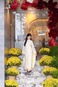 a woman is walking down some stairs with flowers at SHI HOUSE by Haviland in Danang