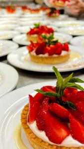 a table topped with white plates topped with strawberries at Logis Hotel Noemys Brive - Restaurant Le Teinchurier in Brive-la-Gaillarde