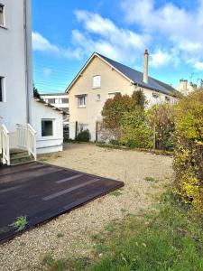 a house with a wooden deck next to a house at Le Chapelloise Ligérienne in La Chapelle-Saint-Mesmin