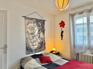 a bedroom with a bed and a painting on the wall at Le Chapelloise Ligérienne in La Chapelle-Saint-Mesmin