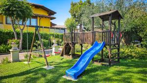 a playground with a slide in a yard at Casa Maria in Manerba del Garda