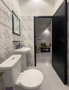 a bathroom with a toilet and a sink at WHITE FLAT ALMADIES in Dakar +55 photos