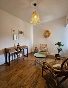 a living room with a table and chairs and a chandelier at La Casa Nomade in Issigeac