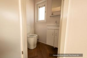 a bathroom with a toilet and a window at Texelcampings - Kogerstrand in De Koog +22 photos