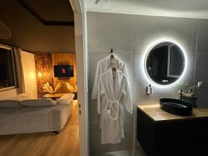 a bathroom with a white robe hanging on a wall at Premium suite with jacuzzi 4 étoiles in Pleyber-Christ