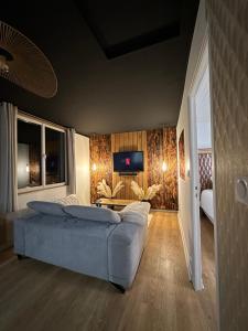 a bedroom with a bed and a tv on a wall at Premium suite with jacuzzi 4 étoiles in Pleyber-Christ