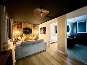 a living room with a couch and a bedroom at Premium suite with jacuzzi 4 étoiles in Pleyber-Christ