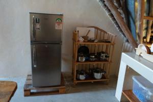 a kitchen with a refrigerator and a shelf with pots at Rasal homes in Gazi +13 photos