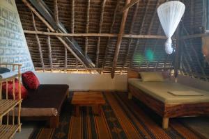 a room with a bed and a couch and a table at Rasal homes in Gazi