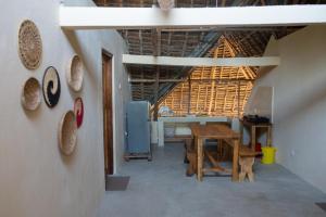 a dining room with a table and plates on the wall at Rasal homes in Gazi