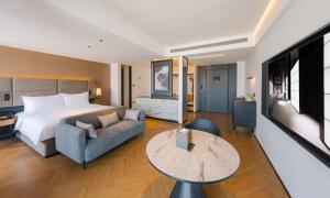 a hotel room with a bed and a couch and a table at Intercity Hotel & Serviced Apartment Phnom Penh Downtown in Phnom Penh
