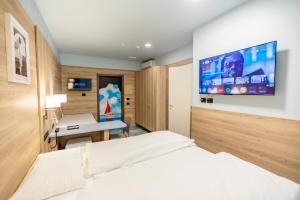 a bedroom with a bed and a desk and a tv at Ferrucci Rooms in Marina di Cecina