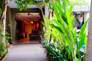 a hallway with plants in front of a restaurant at Golden Temple Villa in Siem Reap