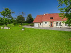 a house with a red roof on a green lawn at Les Bergeronnettes in Trénal