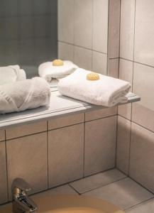 two towels on a shelf in a bathroom at Hôtel La Tour des Anglais in Mayenne