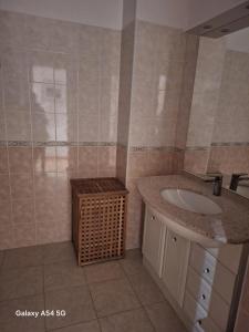 a bathroom with a sink and a wicker basket at Appartement confortable à Propriano avec balcon in Propriano +10 photos
