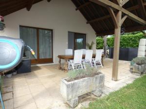 a patio with a table and chairs and a pool at Les Bergeronnettes in Trénal +1 photo