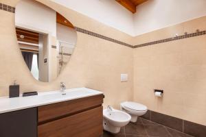 a bathroom with a sink and a toilet and a mirror at Bohemia Apartment in Calmasino +8 photos