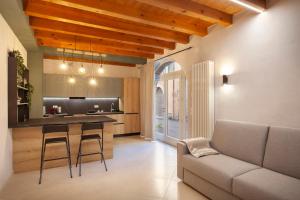 a kitchen and living room with a couch and a table at Bohemia Apartment in Calmasino