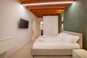 a bedroom with a bed and a tv on a wall at Bohemia Apartment in Calmasino