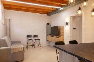 a living room with a table and chairs and a television at Bohemia Apartment in Calmasino
