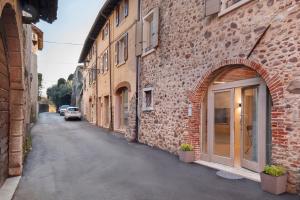 an alley between two brick buildings with a car parked on it at Bohemia Apartment in Calmasino