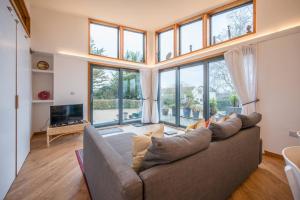 a living room with a couch and large windows at The Orchard Annexe, Framlingham in Framlingham