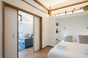 a bedroom with a bed and a blue couch at The Orchard Annexe, Framlingham in Framlingham