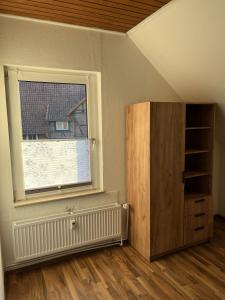 an empty room with a window and a book shelf at Bückeburg Living in Bückeburg