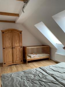 a bedroom with a crib and a wooden cabinet at Reitterhof in Laufnitzdorf in Frohnleiten