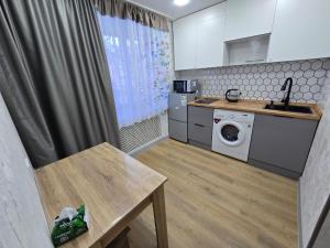 a small kitchen with a washing machine and a table at Возле Нарыка in Ekibastuz +8 photos