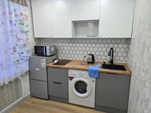 a kitchen with a washing machine and a sink at Возле Нарыка in Ekibastuz