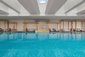 a large swimming pool with blue water in a hotel at Deqing Marriott Hotel in Huzhou