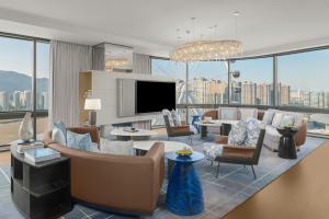 a living room with a couch and chairs and a tv at Deqing Marriott Hotel in Huzhou