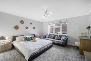 a bedroom with a bed and a couch at 4 BR 6 Beds 3 Bath PS4, Pool Table Parking x4 Close to Legoland & Windsor in Maidenhead
