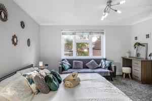a bedroom with a bed and a couch at 4 BR 6 Beds 3 Bath PS4, Pool Table Parking x4 Close to Legoland & Windsor in Maidenhead