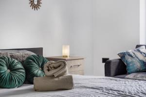 a bedroom with a bed with pillows and a couch at 4 BR 6 Beds 3 Bath PS4, Pool Table Parking x4 Close to Legoland & Windsor in Maidenhead +20 photos