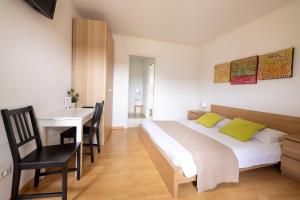 a bedroom with a bed and a table and a desk at Locanda al Castello in Travesio