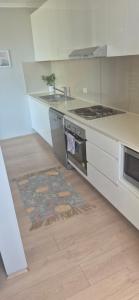 a kitchen with a stove and a rug on the floor at Spacious Apartment Oasis in Bankstown