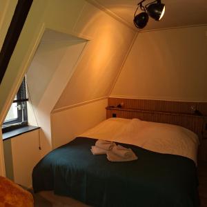 a bedroom with a bed in a attic at B en B de 8 Wieken in Oosterwolde +6 photos