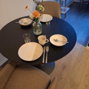 a black table with plates and utensils on it at B en B de 8 Wieken in Oosterwolde