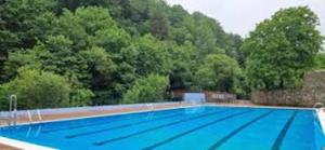 an empty swimming pool with trees in the background at Casa Vizcaya, Casa rural para grupos de hasta 20 personas en Lanestosa, ideal para reuniones y celebraciones tranquilas in Lanestosa